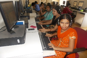 A group of people sitting in front of computers.