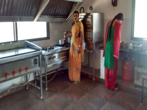 Two women standing in a kitchen preparing food.